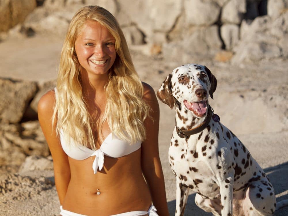Dalmatiner und junge Frau am Strand